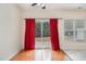 Bright dining area with hardwood floors, sliding glass door to the backyard, and red curtains at 705 Keystone Park Dr # 51, Morrisville, NC 27560