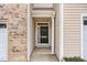 Covered entrance featuring a black front door, brick accents, and neutral siding at 705 Keystone Park Dr # 51, Morrisville, NC 27560