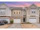 Attractive townhouse with neutral siding, brick accents, and attached garages at 705 Keystone Park Dr # 51, Morrisville, NC 27560
