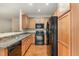 Functional kitchen featuring a stainless steel sink, black appliances, and wood cabinets at 705 Keystone Park Dr # 51, Morrisville, NC 27560