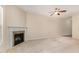 Carpeted living room with fireplace, ceiling fan, and view of the backyard at 705 Keystone Park Dr # 51, Morrisville, NC 27560