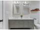 Bathroom featuring a double vanity with marble top, gray cabinet, and dual mirrors at 7103 Big Horn Dr, Hillsborough, NC 27278
