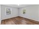 Bedroom featuring two windows and wood-look flooring at 7103 Big Horn Dr, Hillsborough, NC 27278