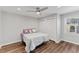 Cozy bedroom with a ceiling fan, window, wood-look floors, and a closet with paneled doors at 7103 Big Horn Dr, Hillsborough, NC 27278
