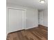 Bedroom featuring wood-look floors, a double closet with paneled doors, and neutral walls at 7103 Big Horn Dr, Hillsborough, NC 27278