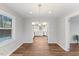 Open dining room with hardwood floors, view into the kitchen with white cabinets at 7103 Big Horn Dr, Hillsborough, NC 27278