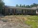 Classic brick home featuring black shutters, a simple walkway, and fresh landscaping at 7103 Big Horn Dr, Hillsborough, NC 27278