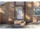 Close-up of the front door entrance with brick steps and a covered porch at 7103 Big Horn Dr, Hillsborough, NC 27278