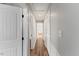 Bright hallway with wood-look floors, white doors, and neutral paint at 7103 Big Horn Dr, Hillsborough, NC 27278