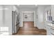 Open kitchen with stainless steel appliances, white cabinets, and hardwood floors at 7103 Big Horn Dr, Hillsborough, NC 27278