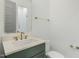 Elegant bathroom featuring a green vanity, gold fixtures, and a framed mirror at 7112 Camp Side Ct, Raleigh, NC 27613