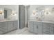 Bathroom with dual sinks, custom cabinets and marble floors, with elegant lighting at 7112 Camp Side Ct, Raleigh, NC 27613