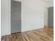 Minimalist bedroom with hardwood floors, white walls, and a gray paneled door at 7112 Camp Side Ct, Raleigh, NC 27613