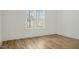 Sunny bedroom with hardwood floors and a large window with views of surrounding neighborhood at 7112 Camp Side Ct, Raleigh, NC 27613