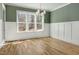 Inviting dining room with wainscoting and three large windows with wooded views at 7112 Camp Side Ct, Raleigh, NC 27613