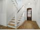 Bright entryway featuring hardwood floors, staircase, and wooden door with an ornate light fixture at 7112 Camp Side Ct, Raleigh, NC 27613