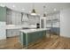 Modern kitchen with stainless steel refrigerator, center island and grey cabinets at 7112 Camp Side Ct, Raleigh, NC 27613