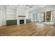 Spacious living room with hardwood floors, a fireplace, built-in shelving, and access to the screened-in porch at 7112 Camp Side Ct, Raleigh, NC 27613