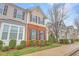 Charming townhome with well-maintained lawn, manicured bushes, and a sidewalk leading to other homes at 714 Cupola Dr, Raleigh, NC 27603