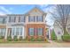 Inviting townhome features a brick facade, complemented by neat landscaping and black window shutters at 714 Cupola Dr, Raleigh, NC 27603
