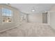 Large carpeted bonus room with natural light and a ceiling fan, ready for your personal touch at 714 Fairway Dr, Mebane, NC 27302