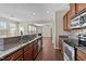 Open kitchen flows into living area, featuring stainless appliances, stone counters and hardwood flooring at 714 Fairway Dr, Mebane, NC 27302
