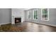 Open-concept living room featuring wood floors, a fireplace, and bright windows at 7521 Percussion Dr, Apex, NC 27539