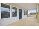 Spacious covered porch showcasing natural wood flooring and a stylish front door at 815 Graham St, Burlington, NC 27217