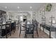 A dining room with a black table and chairs, with an open concept leading to the living room at 905 Arnold Place Dr, Fuquay Varina, NC 27526