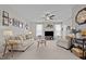 Bright living room with neutral furniture, a ceiling fan, and large windows with sheer curtains at 905 Arnold Place Dr, Fuquay Varina, NC 27526