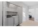 Well-lit laundry room featuring side-by-side washer and dryer, plus storage and access to the living area at 105 Solstice Cir, Cary, NC 27513