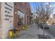 Outdoor seating area with yellow chairs next to a brick building with large windows and cityscape background at 1241 S Blount Street # 201, Raleigh, NC 27601