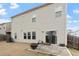 Back exterior of home, featuring a patio, sliding glass door, and well-maintained lawn at 1610 Stone Rd, Durham, NC 27703