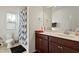 Bathroom featuring a vanity with dark wood cabinets, a framed mirror, and a shower/tub with a patterned curtain at 1610 Stone Rd, Durham, NC 27703