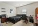 Cozy bedroom with a black bed frame, a desk area by the window, and neutral carpet flooring at 1610 Stone Rd, Durham, NC 27703