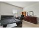 Bright bedroom with a dark-colored bed, a desk, and a dresser, with a window providing natural light at 1610 Stone Rd, Durham, NC 27703