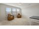 Bright bonus room with carpet flooring, large windows, and two chairs, ideal for relaxation or entertainment at 1610 Stone Rd, Durham, NC 27703