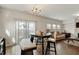 A dining area with a modern table and chairs, alongside a sunlit living room at 1610 Stone Rd, Durham, NC 27703