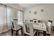 Dining room with wood floors, white table and chairs, decorative wall art, and bright natural light at 1610 Stone Rd, Durham, NC 27703