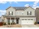 Charming two-story home featuring solar panels, a two-car garage, and a cozy front porch at 1610 Stone Rd, Durham, NC 27703