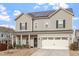 Beautiful two-story home featuring solar panels, a two-car garage, and a welcoming covered porch at 1610 Stone Rd, Durham, NC 27703