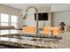 Close-up of a kitchen island featuring granite countertops, a stainless steel sink, and modern fixtures at 1610 Stone Rd, Durham, NC 27703