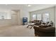 Bright living room featuring carpeted floors, comfortable seating, and large windows for natural light at 1610 Stone Rd, Durham, NC 27703