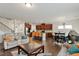 Spacious living room seamlessly integrates with a modern kitchen featuring a central island and stainless steel appliances at 1610 Stone Rd, Durham, NC 27703