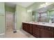 Main bathroom with double vanity, dark wood cabinets, neutral walls and flooring and access to the walk-in shower at 1610 Stone Rd, Durham, NC 27703