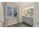 Bright bathroom featuring a double vanity, sleek black hardware, and a view to the neighborhood at 206 Steep Bank Dr, Cary, NC 27518
