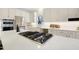 Close up of kitchen island cooktop with white countertop and stainless steel appliances at 206 Steep Bank Dr, Cary, NC 27518