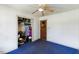 This bedroom features blue carpet, a ceiling fan, a closet, and a door at 245 Cedar Crk Rd, Franklinton, NC 27525