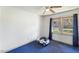 This bedroom features blue carpet, a ceiling fan, a white toy car, and a window with curtains at 245 Cedar Crk Rd, Franklinton, NC 27525