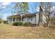 Quaint single-story home with a covered front porch, complemented by mature trees and garden shrubs at 245 Cedar Crk Rd, Franklinton, NC 27525